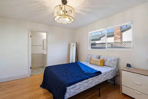 a bedroom with a bed and a chandelier