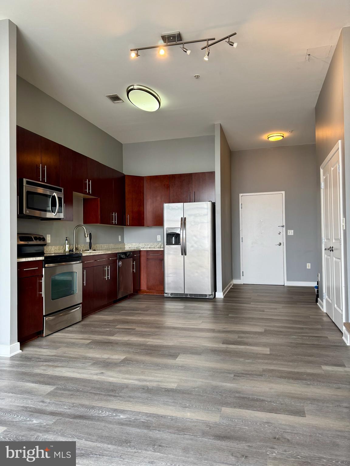 157 Fleet Street, Unit PH14 Oxon Hill, MD 20745 - Photo 6 of 27 a large kitchen with stainless steel appliances granite countertop a stove and a refrigerator