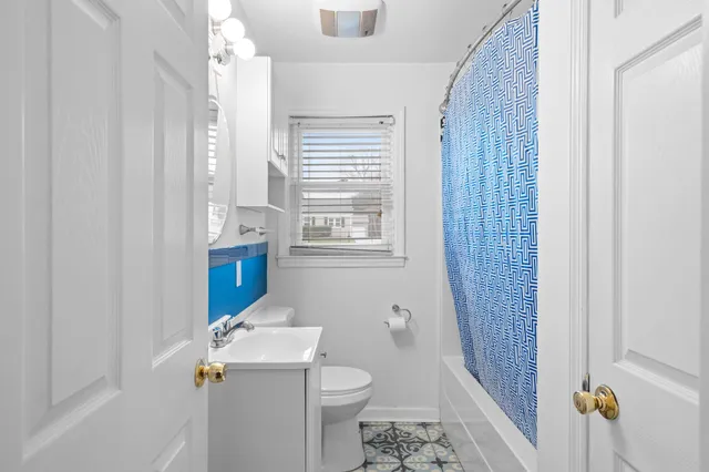 a bathroom with a sink toilet and window