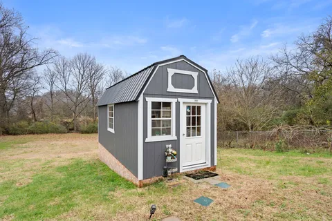 a view of an entryway with a floor to ceiling window and potted plants