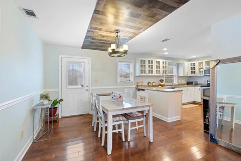 a kitchen with kitchen island a dining table and chairs