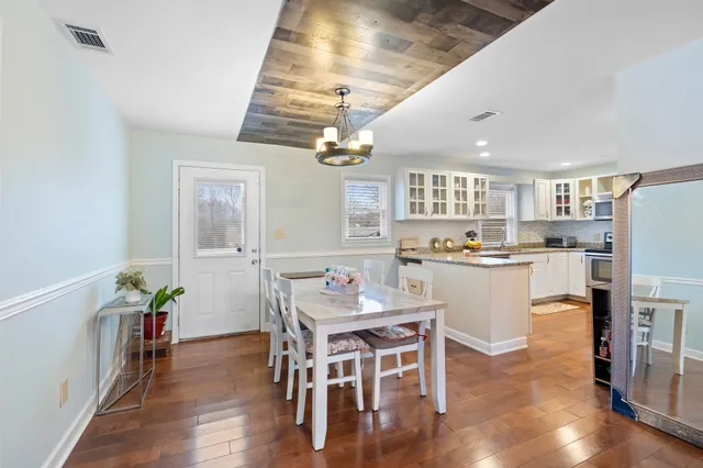 a kitchen with kitchen island a dining table and chairs