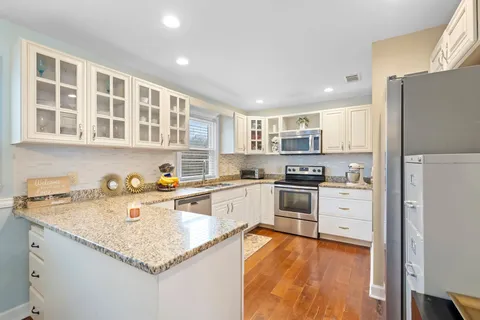 a kitchen with stainless steel appliances granite countertop a refrigerator and a stove top oven