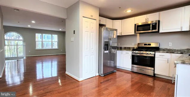 a kitchen with stainless steel appliances granite countertop a stove a refrigerator and a microwave
