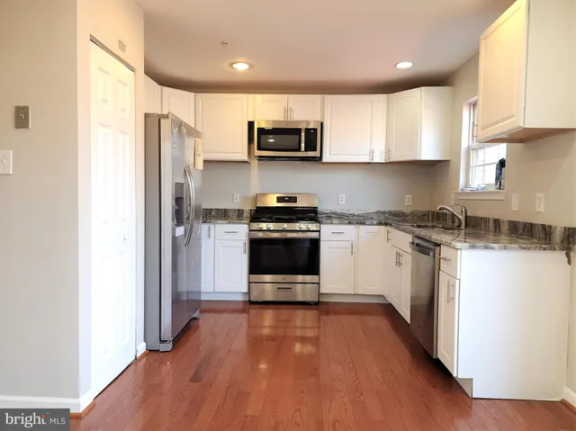 a kitchen with granite countertop a refrigerator and a stove