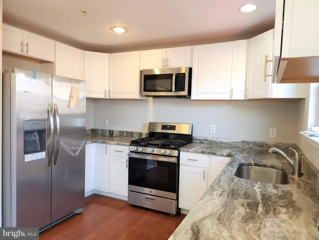 a kitchen with stainless steel appliances granite countertop a stove a refrigerator and a microwave
