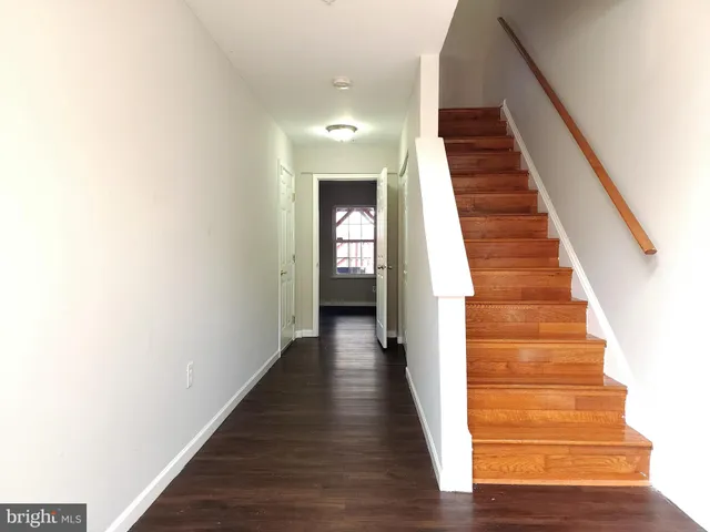 a view of a hallway with wooden floor and entryway