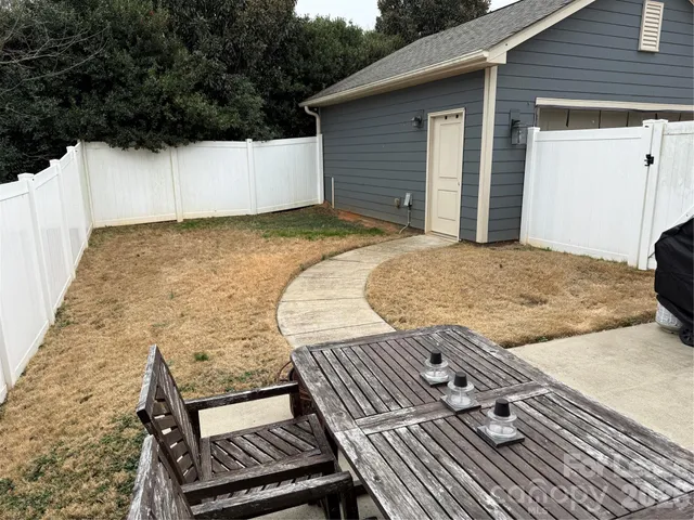 a view of a backyard with wooden fence