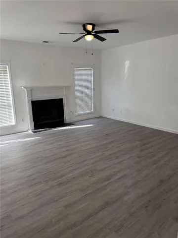 a view of empty room with wooden floor and fireplace