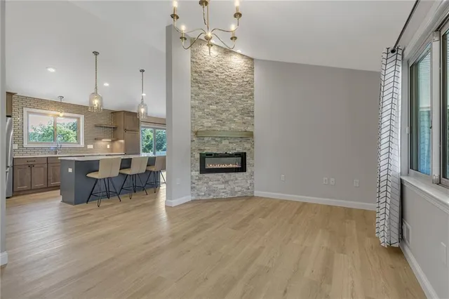 an empty room with kitchen view and wooden floor