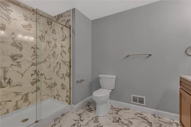 a bathroom with a toilet and a shower
