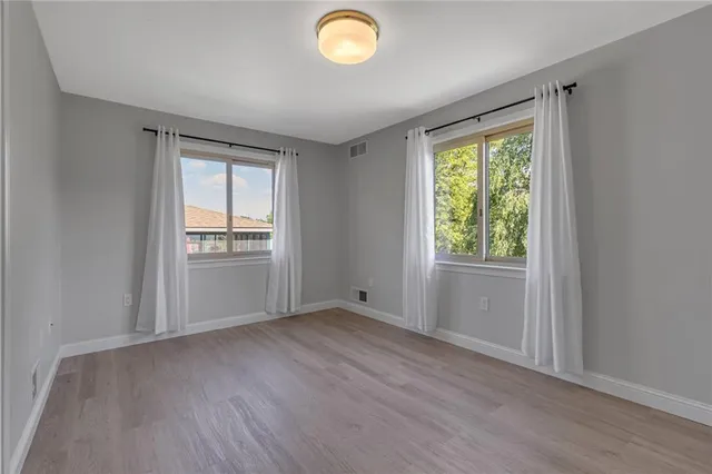 an empty room with windows and cabinet
