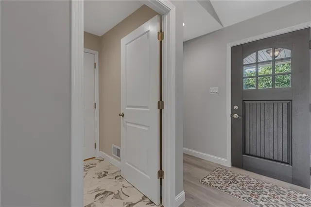 a view of hallway with window and wooden floor