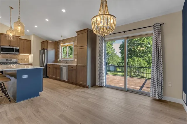 a view of kitchen with granite countertop stainless steel appliances and wooden floor