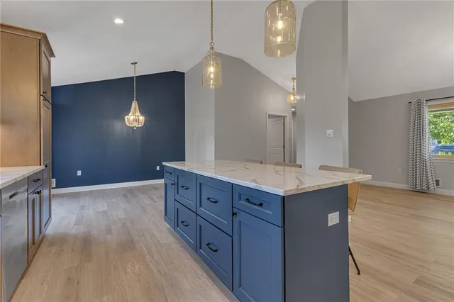 a kitchen with granite countertop a sink and a refrigerator