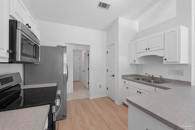a kitchen with white cabinets and a sink