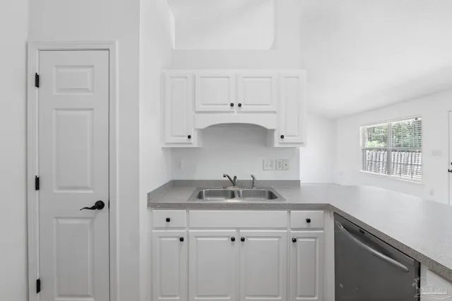a kitchen with cabinets stainless steel appliances and a counter space