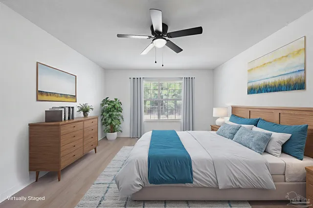 an empty room with wooden floor chandelier fan and windows