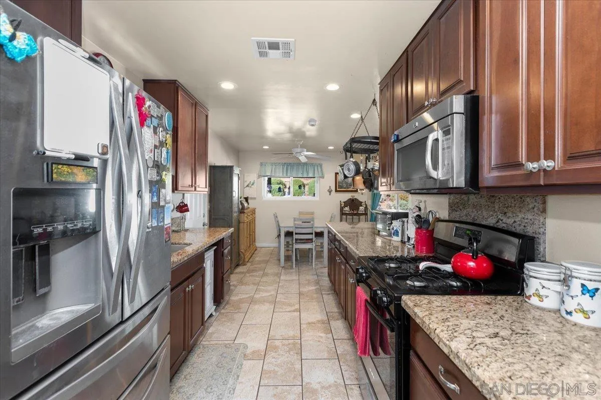 9254 Shadow Hill Road Santee, CA 92071 - Photo 14 of 34 a kitchen with stainless steel appliances granite countertop a sink stove and refrigerator