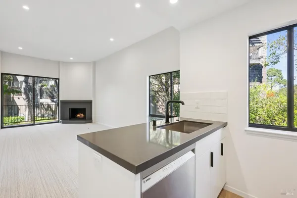 a kitchen with stainless steel appliances granite countertop a sink a microwave and wooden floor