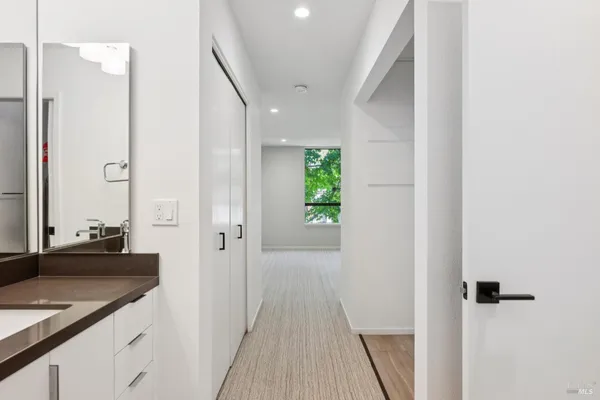 a view of a hallway with wooden floor and staircase