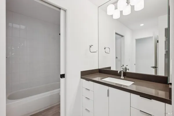 a bathroom with a sink a large mirror and a bathtub