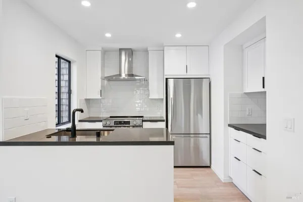 a kitchen with granite countertop a refrigerator and a sink