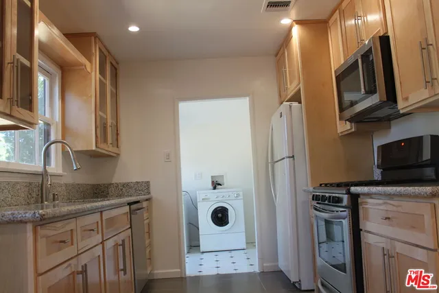 a kitchen with stainless steel appliances granite countertop a refrigerator and a sink