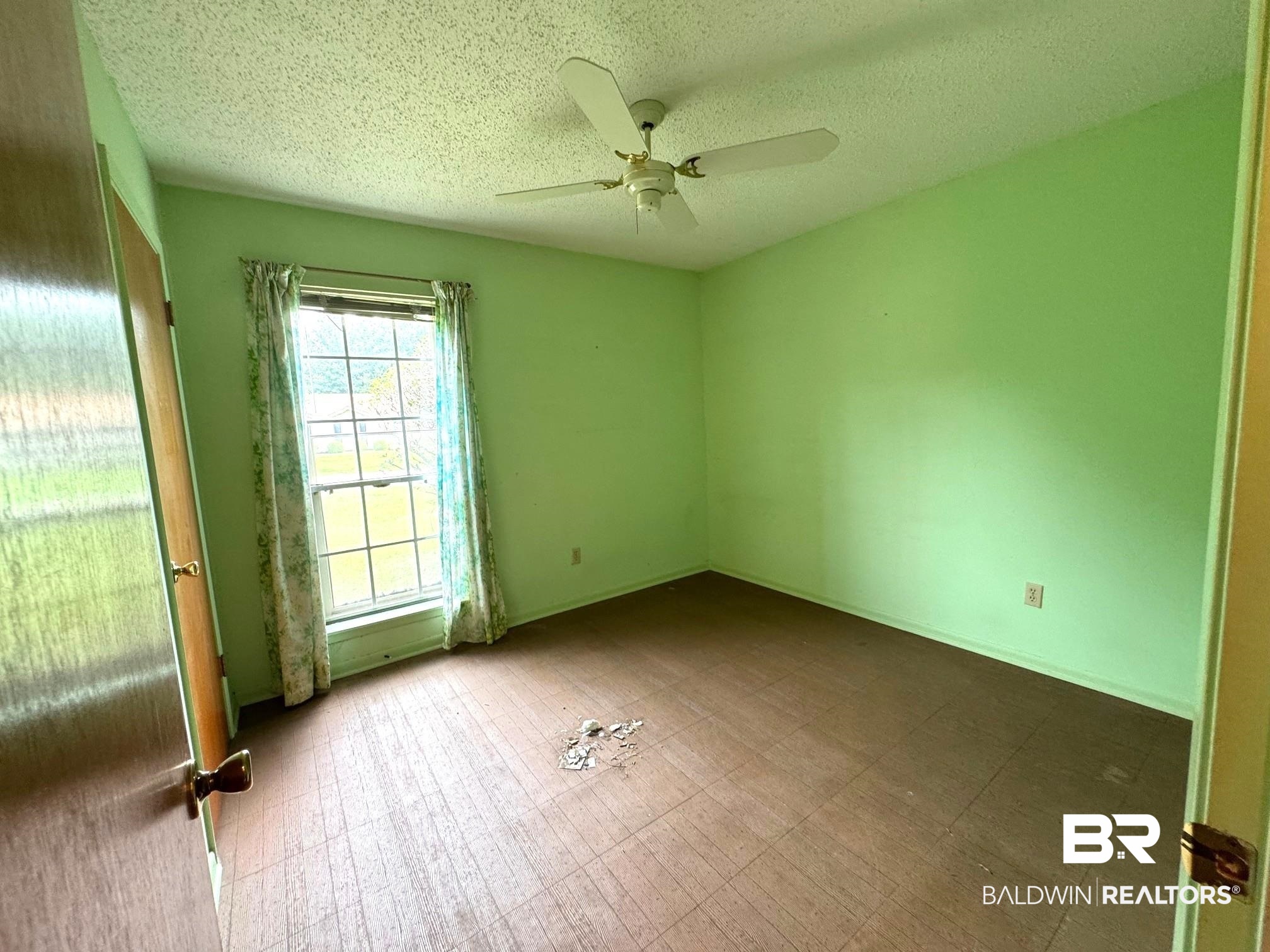 5198 Lancelot Drive Mobile, AL 36619 - Photo 10 of 30 Empty room featuring a ceiling fan, a textured ceiling, and tile patterned floors