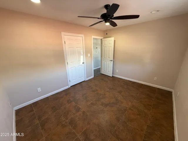 an empty room with a ceiling fan and a window