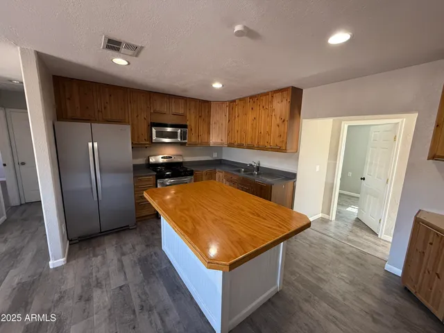 a kitchen with stainless steel appliances granite countertop a refrigerator a sink and a stove