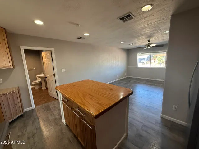 a kitchen with stainless steel appliances a sink a stove top oven a refrigerator cabinets and wooden floor