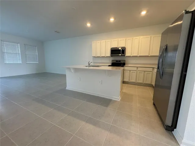 a kitchen with stainless steel appliances a refrigerator sink and microwave