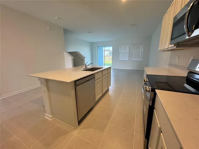 a kitchen with stainless steel appliances a sink stove and cabinets