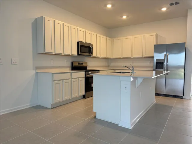 a kitchen with stainless steel appliances a sink a stove a microwave and cabinets