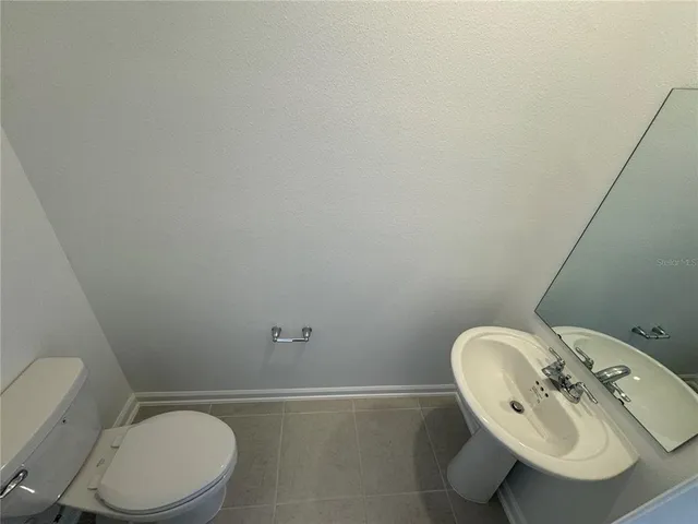 a bathroom with a sink mirror and toilet