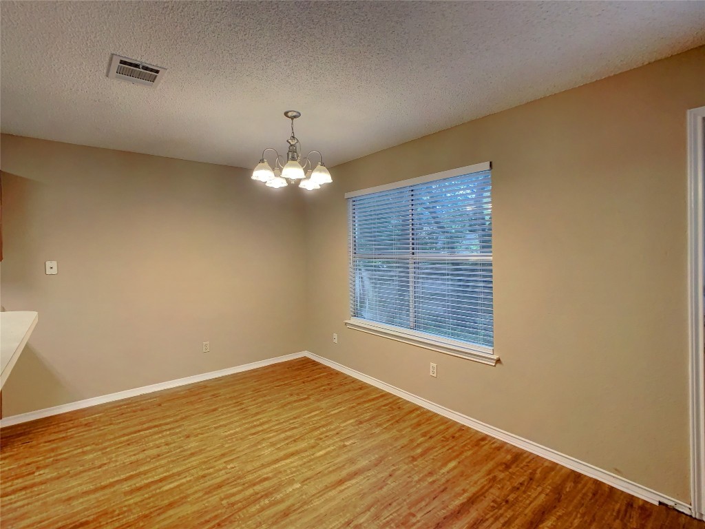 12705 Modena Trail Austin, TX 78729 - Photo 5 of 16 a view of an empty room with wooden floor and a window