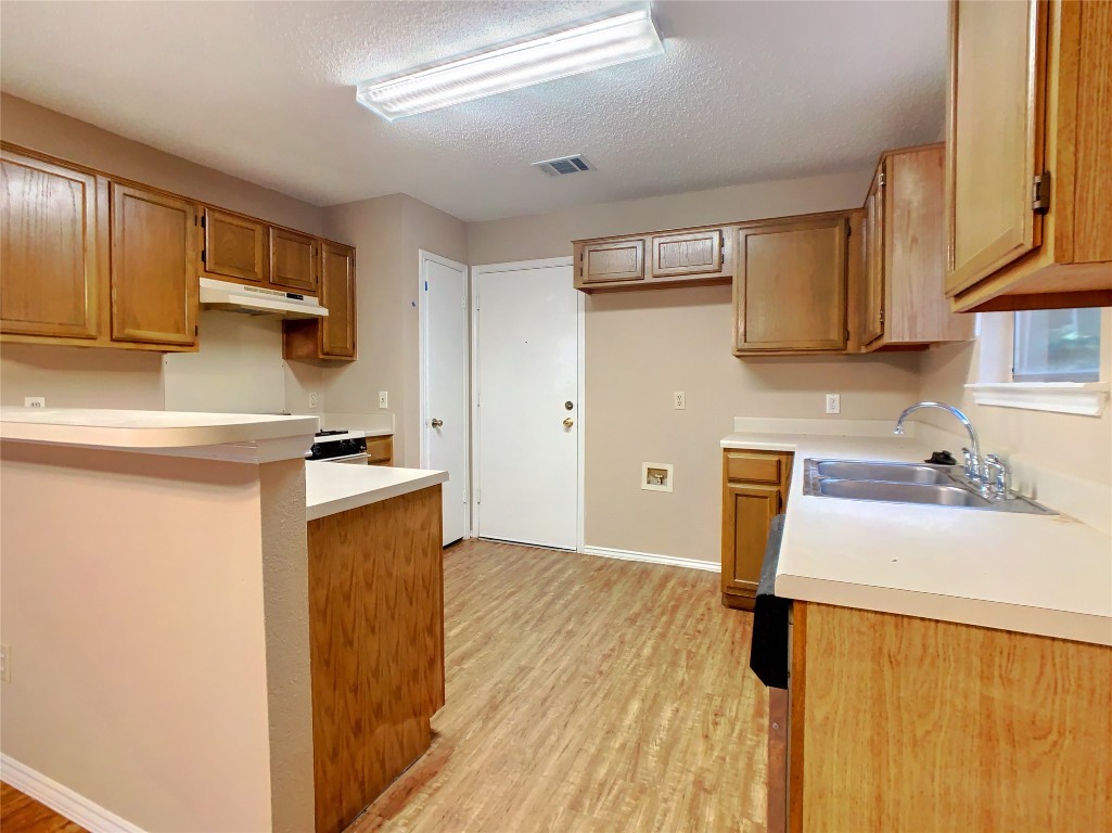 12705 Modena Trail Austin, TX 78729 - Photo 6 of 16 a kitchen with a sink a stove and a refrigerator