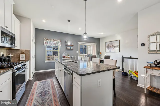 a kitchen with granite countertop a sink a stove and cabinets