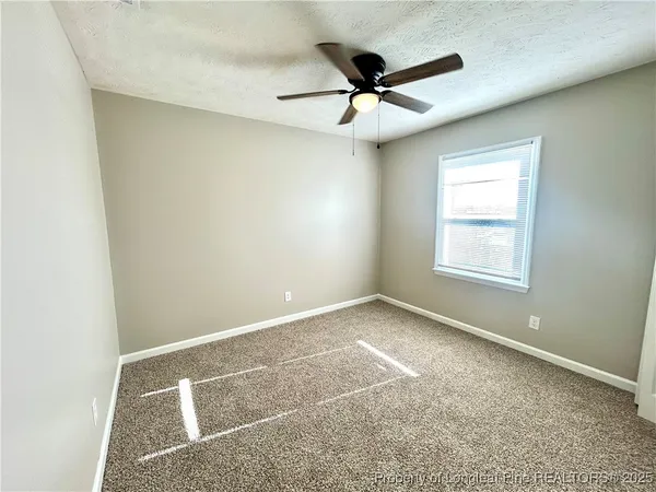 a view of a big room with carpet and windows