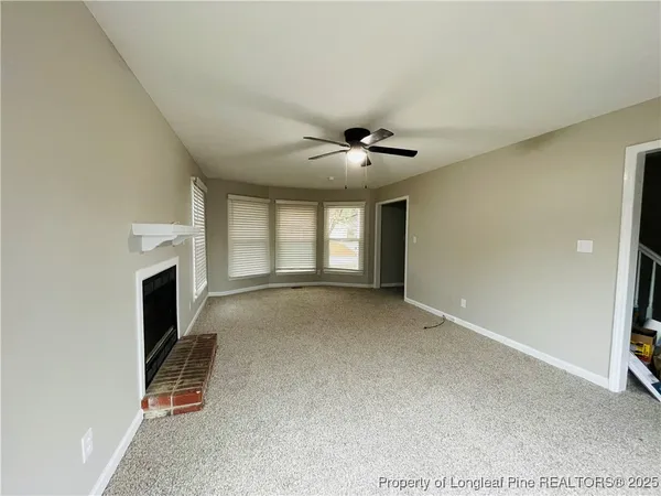 a view of a livingroom with a fireplace and window