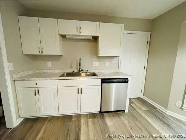 a kitchen with granite countertop white cabinets and white appliances
