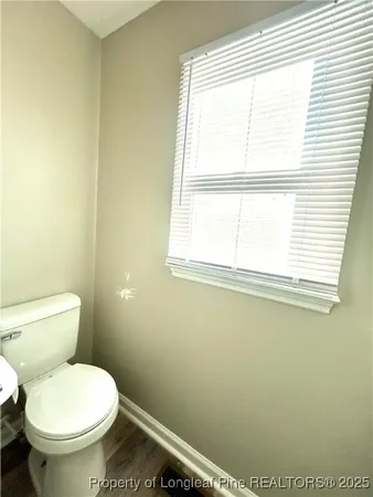 a white toilet sitting in a bathroom next to a window