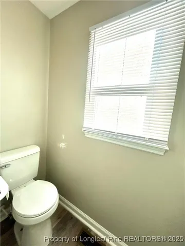 a white toilet sitting in a bathroom next to a window