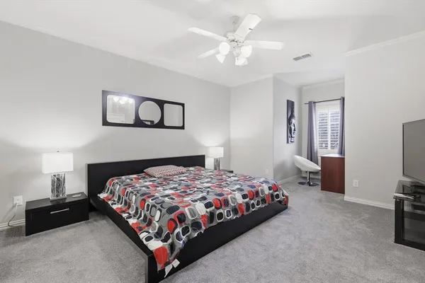 a bedroom with a bed and a tv on dresser