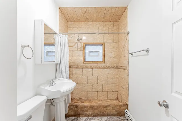 a bathroom with a toilet sink and mirror