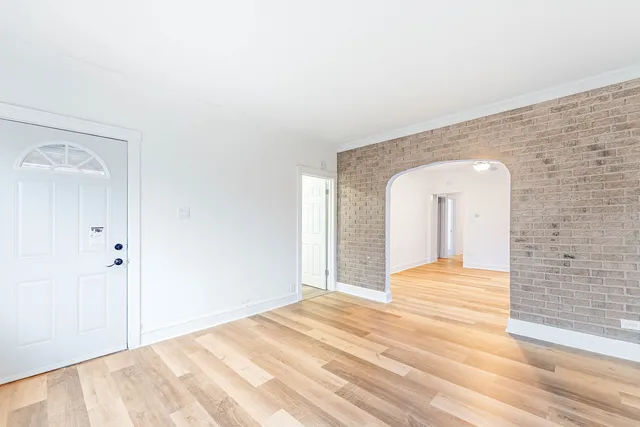 a view of a livingroom with wooden floor and a bathroom