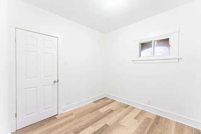 a view of a small space with wooden floor and a window