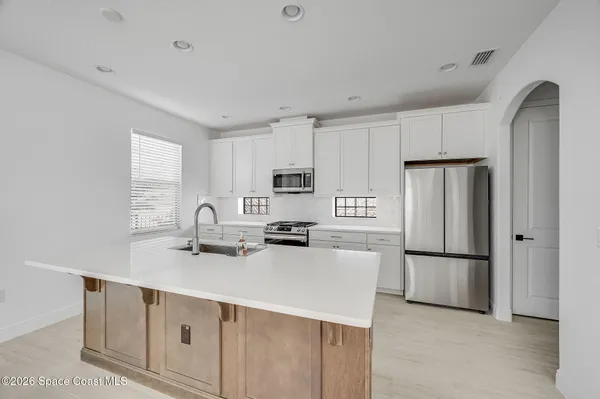 a kitchen with stainless steel appliances a refrigerator stove microwave and sink