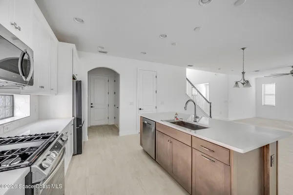a kitchen with stainless steel appliances granite countertop a sink a stove and a refrigerator
